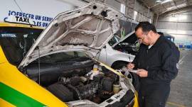 Un técnico revisa el motor de un taxi, en Quito.