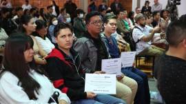 Los beneficiarios de las ayudas económicas muestran el certificado del Municipio de Quito.
