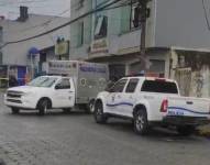 Un vehículo de Medicina Legal y un patrullero de la Policía parqueados junto a la escena del crimen.