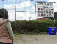 Andrea Báez, en la cancha de ecuavoley de La Comuna, observa la pancarta con las fotografías de las víctimas.