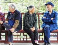Imagen referencial de cinco ancianos de China sentados en una banca.