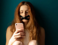 Mujer con su smartphone y cinta en la boca.