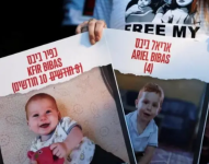 Los niños sostienen retratos de Kfir Bibas, el rehén más joven secuestrado por los militantes de Hamas en el ataque del 7 de octubre, su hermano Ariel Bibas, su padre Yarden Bibas.