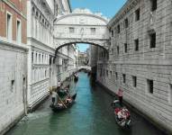 Un grupo de góndolas cruzando por el canal debajo del famoso puente de los suspiros en la ciudad de Venecia, Italia.
