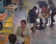 Momento en el que un delincuente arrancha el celular a un cliente.