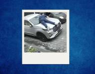 El hombre se subió cal capot de su auto para evitar que se lo roben.