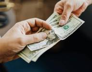 Persona entregando dinero a otra.