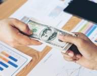 Persona entregando dinero a otra.