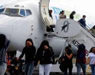 Personas bajando de un avión.
