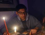 Este 20 de noviembre se reinicia el plan de racionamiento eléctrico. En la imagen, se observa a adolescentes realizando sus deberes con velas debido a los cortes de luz.