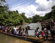 Migrantes descienden de una canoa antes de llegar a la Estación de Recepción Migratoria (ERM) de Lajas Blancas, el 18 de diciembre de 2023, luego de atravesar la selva del Darién (Panamá).