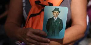 Una mujer sostiene hoy imágenes de José Gregorio Hernández con motivo de su ceremonia de beatificación.