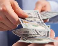 Persona entregando dinero a otra.