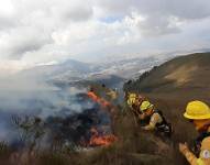 Efectivos del Cuerpo de Bomberos de Quito apaga el fuego en el volcán Pichincha.