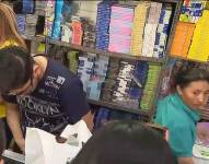 Clientes adquiriendo útiles escolares al interior de una papelería en Quito.