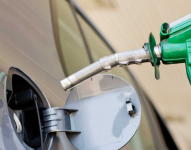 Persona poniendo gasolina a un vehículo.