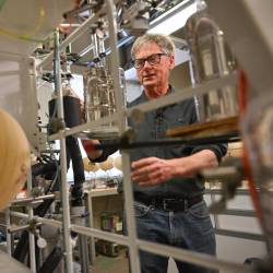 El profesor Ralph Keeling explica cómo se sella el dióxido de carbono en tubos de vidrio para el análisis isotópico de muestras de aire, como parte del estudio de la Curva de Keeling en la Institución Scripps de Oceanografía de la UC San Diego, el 11 de abril de 2025.