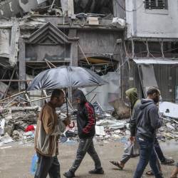 Imagen de ciudadanos de la Franja de Gaza en medio de la edificaciones destruidas.