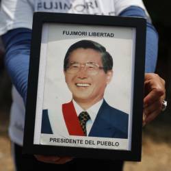 Fotografía de archivo en la que se registró a un seguidor del expresidente peruano Alberto Fujimori al sostener en sus manos una foto del exmandatario, en Lima.