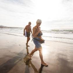 En la imagen de archivo, un hombre y una mujer pasean por la orilla de la Playa del Inglés, en Gran Canaria, España.