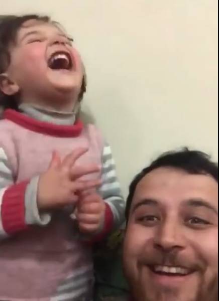 Padre enseña a su hija a reír durante los bombardeos en Siria