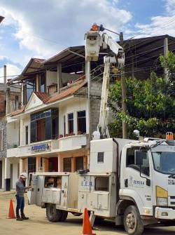Un técnico realiza una revisión en un poste de alumbrado eléctrico.