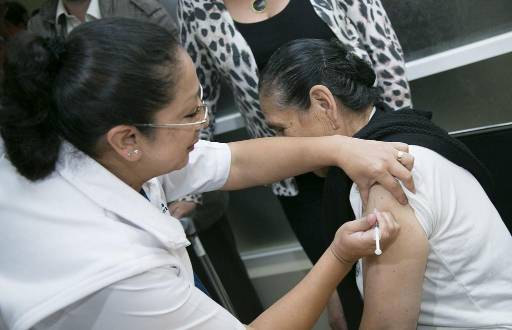 Imagen de una mujer siendo vacunada contra la influenza por el Ministerio de Salud Pública en Ecuador.