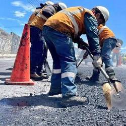 Imagen referencial de obreros trabajando en repavimentación, en Quito.