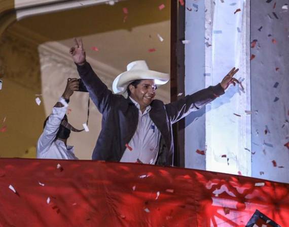 Pedro Castillo saluda a sus simpatizantes desde un balcón.