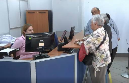 Una adulta mayor realiza un trámite en el SRI.