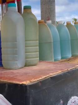 Un puesto improvisado ofrece diésel ecuatoriano en botellas de vidrio o pomas plásticas