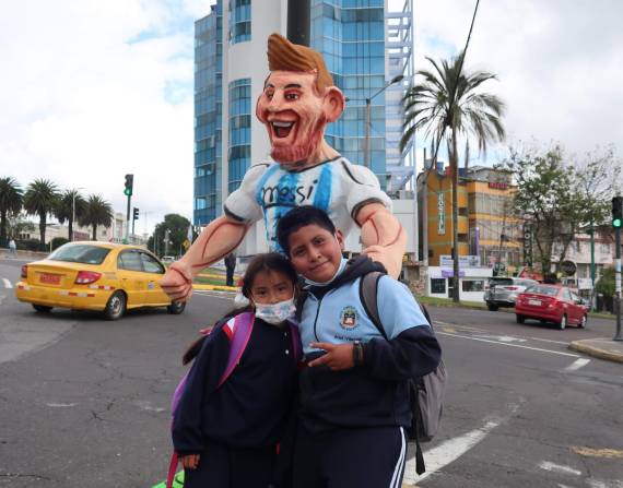 Dos niños posan junto a un monigote de Lionel Messi en Quito (Ecuador). EFE/Juan Francisco Chávez