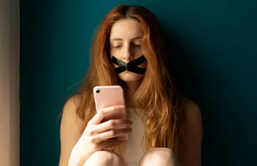 Mujer con su smartphone y cinta en la boca.