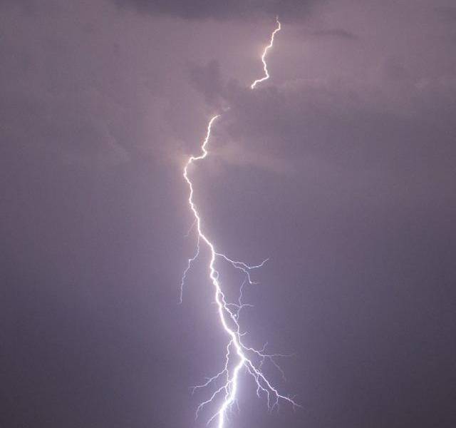 Imagen referencial de un rayo en medio de la ciudad en la noche.