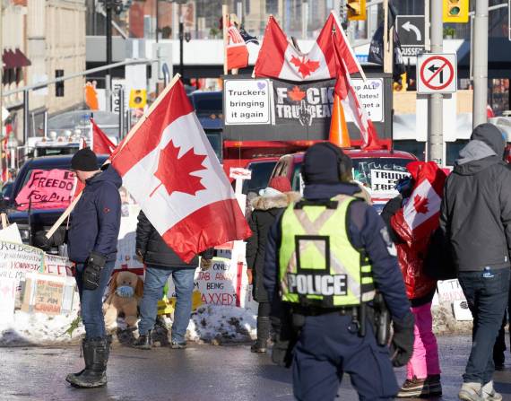 Imagen del pasado 13 de febrero de policías que observan a unos manifestantes en Ottawa, Ontario, Canadá. EFE/EPA/ANDRE PICHETTE