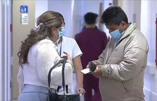 Imagen de dos personas con mascarilla en un hospital.