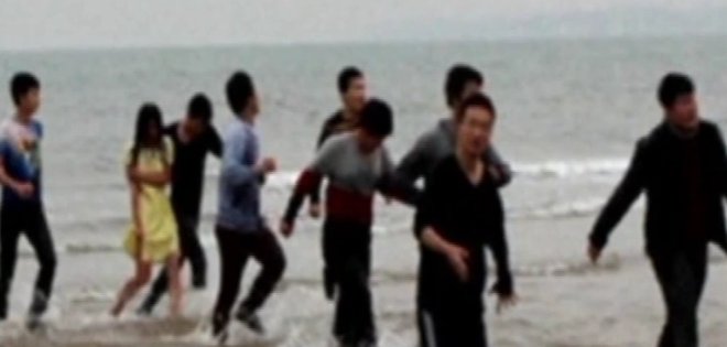 China: jóvenes forman cadena humana para rescatar del mar a una suicida
