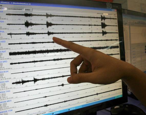 Una persona indica una la señal de un sismo, en una fotografía de archivo.