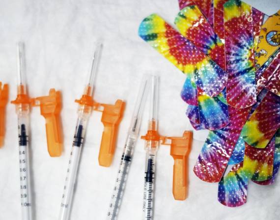 Jeringas y bandas adhesivas sanitarias de colores antes de una sesión de vacunación contra el covid-19.