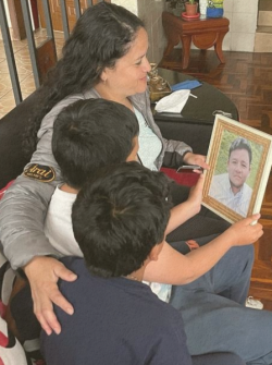Lorena Cortez junto a sus hijos miran la fotografía de su esposo, Walter Ruiz.