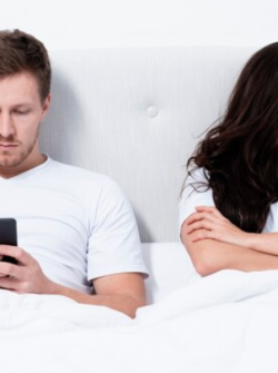 Imagen referencial. Hombre viendo su celular mientras su pareja está enojada.
