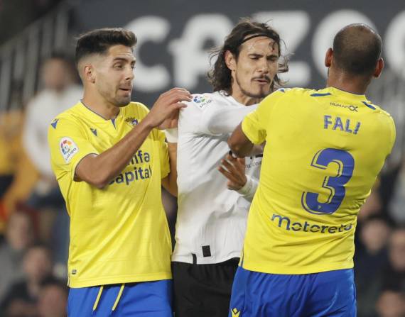 Edinson Cavani (c), del Valencia CF, discute con Fali, zaguero central del Cádiz, en el partido por la fecha 16 de la Liga española.