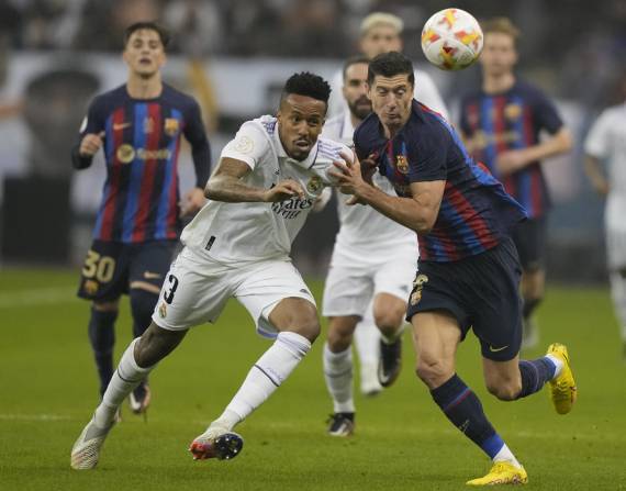 Eder Militao (izquierda) del Real Madrid y Robert Lewandowski del Barcelona pugnan por el balón en la final de la Supercopa española en Riad, Arabia Saudí, el domingo 16 de enero de 2023. (AP Foto/Hussein Malla)