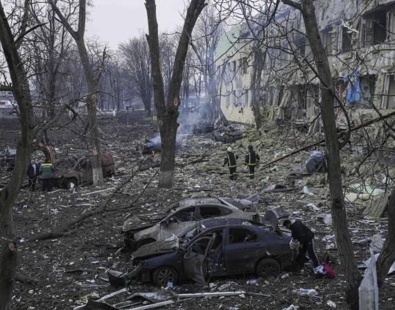 Miembros de los equipos de emergencias de Ucrania trabajan al lado de una maternidad bombardeada.