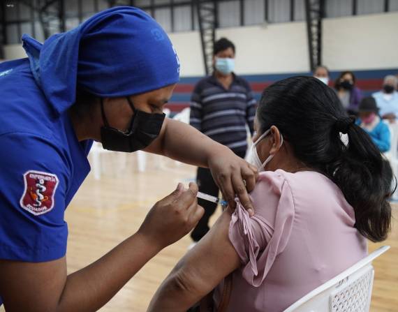 Quito.- Un trabajador de la salud aplica una vacuna contra el COVID-19 a una ciudadana en el Coliseo de Calderón, al norte de la capital.