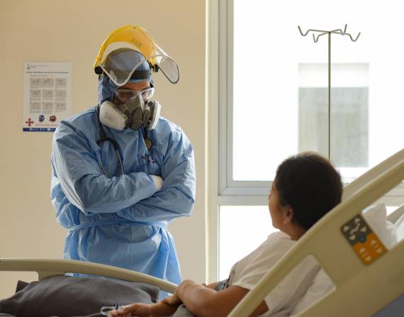 Un médico de la Unidad de Cuidados Intensivos (UCI) del hospital Los Ceibos, de la ciudad portuaria de Guayaquil, que pasa revista a una paciente contagiada covid-19. EFE/Mauricio Torres/Archivo