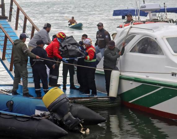 Bomberos y personal de la Armada trasladan un cuerpo recuperado del mar en Puerto Ayora en la Isla Santa Cruz, Galápagos.