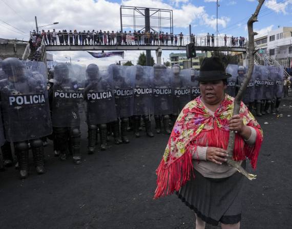 Una mujer se para frente a una línea de policías antidisturbios durante las protestas antigubernamentales convocadas principalmente por organizaciones indígenas, en Quito, Ecuador, el jueves 16 de junio de 2022.