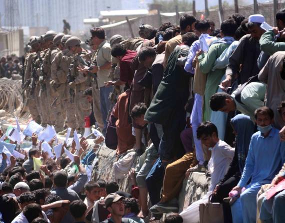 Afganos tratan de mostrar sus credenciales a las fuerzas extranjeras para huir del país en los exteriores del Aeropuerto Internacional Hamid Karzai, en Kabul, Afganistán antes del atentado. EFE