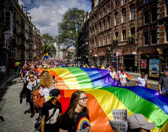 Miles de personas portan una bandera gigante del arcoíris mientras caminan en la Marcha del Orgullo Gay por el centro de Ámsterdam el 29 de julio de 2017. EFE/EPA/SANDER KONING